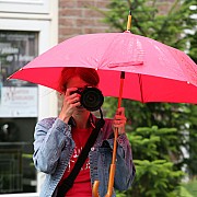 ragazza fotografa con ombrello mentre piove